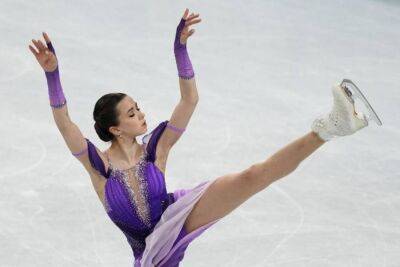 Классный снимок Валиевой в белом топе и юбке на фоне олимпийских колец, на который невозможно наглядеться. ФОТО