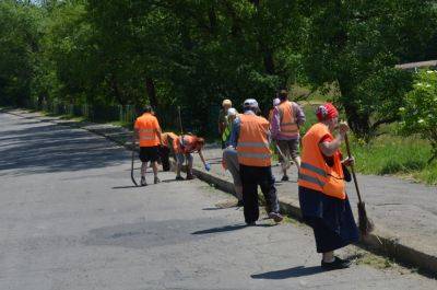 Коррупция в Киеве - коммунальщики вчетвером мели тротуар из плитки - фото