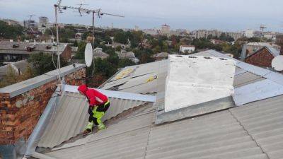 В Харькове закрывают разбитые российской ракетой крыши домов (фото)