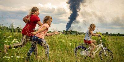 Дети играют на фоне пожара от взрыва. Снимок польского фотографа о войне в Украине стал Фото 2023 года от UNICEF