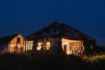 Дома, разрушенные обстрелами россиян, подсветили в селе на Харьковщине (фото)