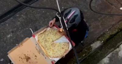 Стал звездой в сети: курьер ест пиццу клиентов и пытается это скрыть (видео)
