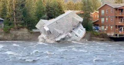 Развалился на части: дом рухнул в реку во время наводнения (фото)