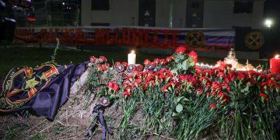 Крушение самолета Пригожина: россияне приносят цветы к бывшему офису ЧВК Вагнера, в окнах здания зажгли свет в виде креста — фото