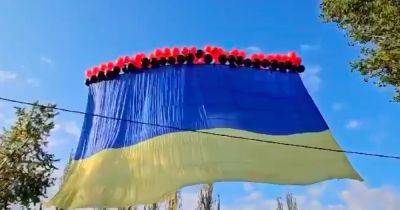 В небе Донецка летает огромный украинский флаг на красно-черных шарах