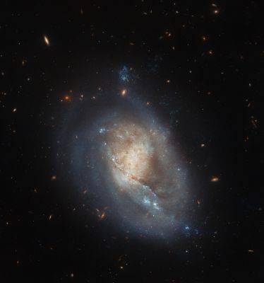 Под давлением: Hubble показал «пробивающуюся» галактику